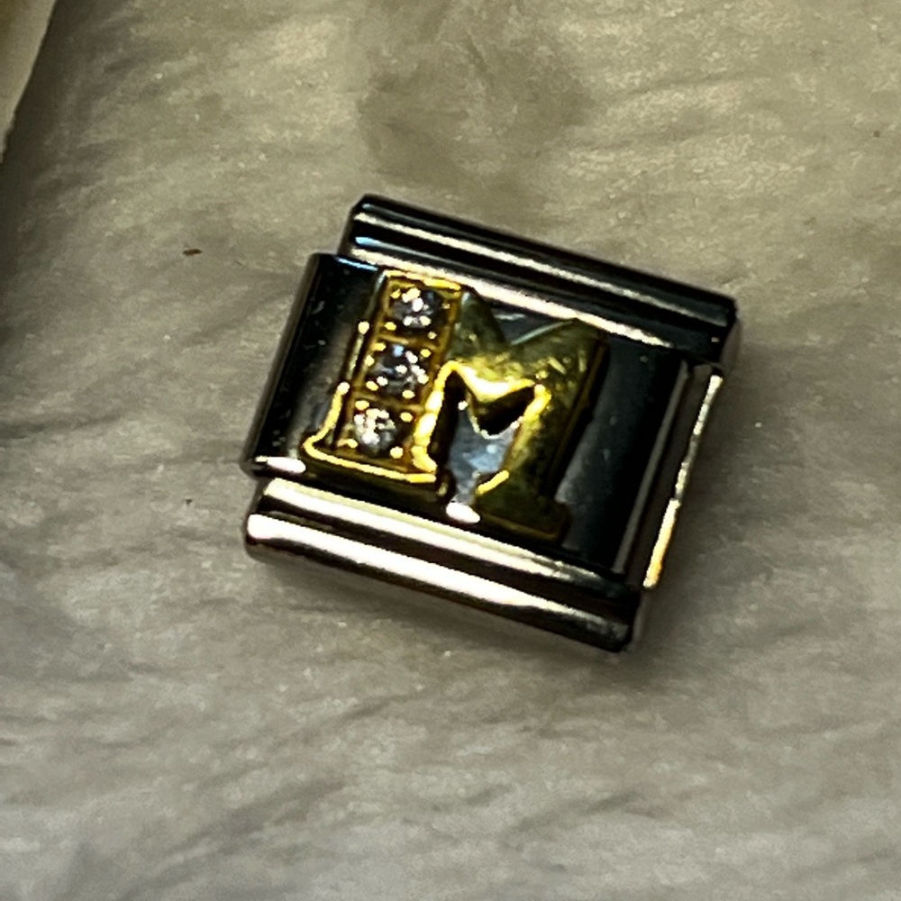 This is a piercing pagoda “M“ link for an expandable bracelet.